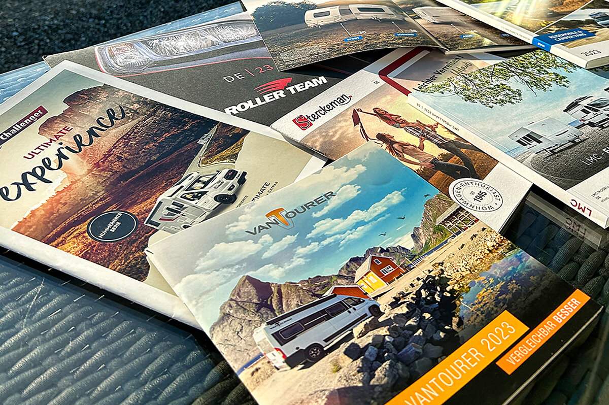 In der Fritz Berger Campingwelt finden Sie eine große Auswahl an Camping- und Freizeitartikeln von Top-Marken. Verschiedene Magazine liegen auf einem Stapel.