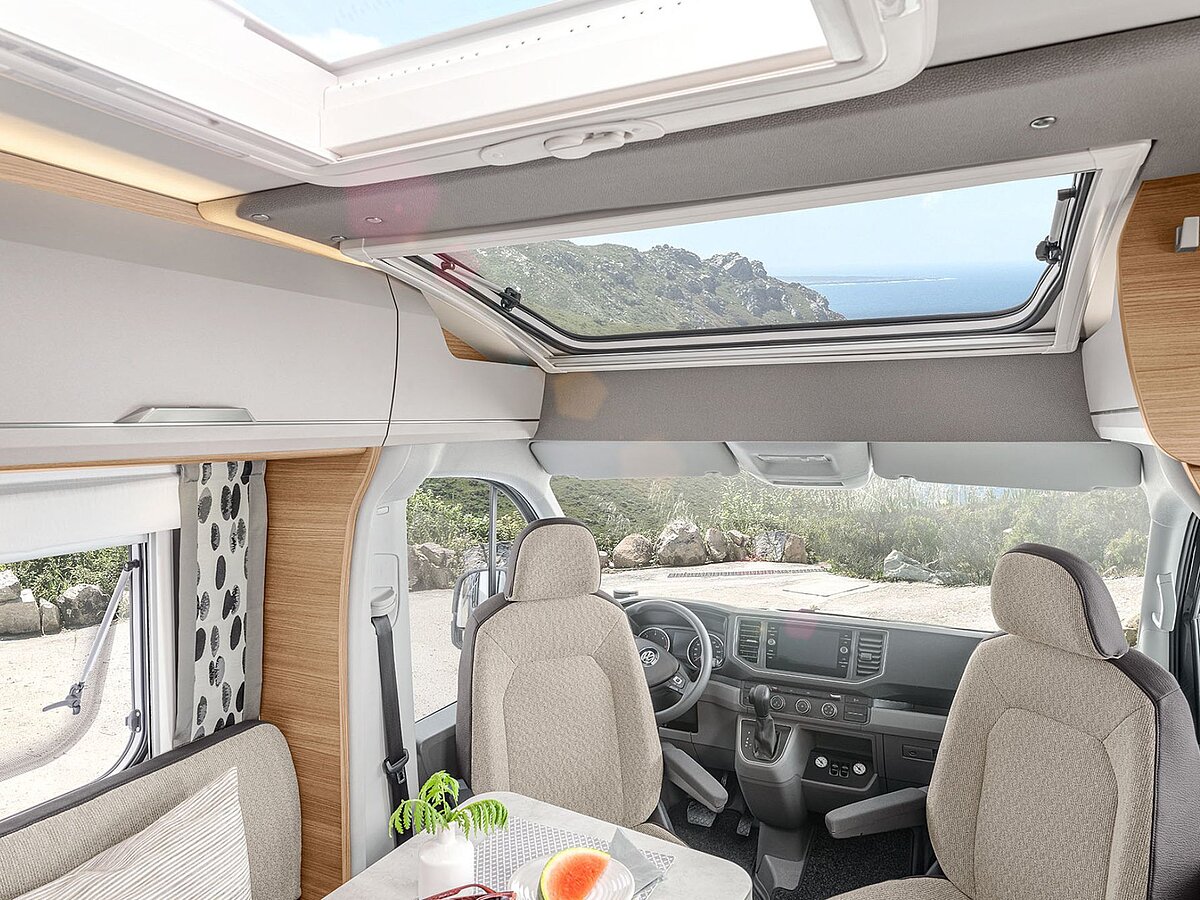 Blick zum Fahrerhaus des Wohnmobils mit gedrehten Sitzen und Panoramafenster