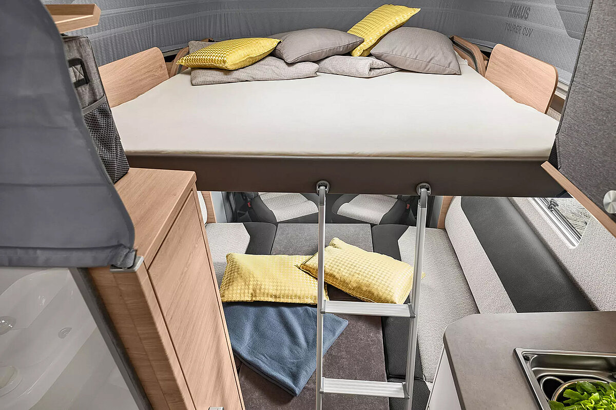 Das Hubbett des KNAUS TOURER CUV CUVISION 2024 wird einfach über dem Fahrerbereich ausgeklappt.
