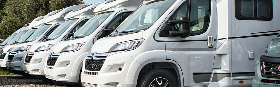 Mehrere Wohnmobile stehen schräg nebeneinander.
