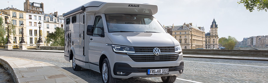 Ein elegantes Wohnmobil von Knaus auf VW-Basis. Es parkt in einer städtischen Umgebung.