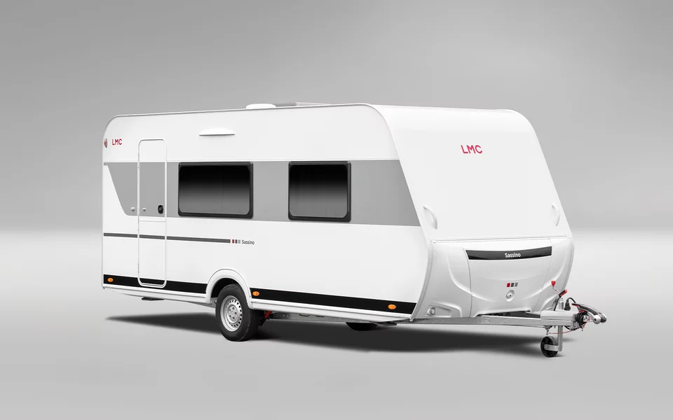 Weißer Wohnwagen mit dunkeln Details vor grauem Hintergrund.