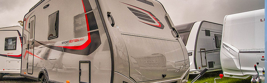 Mehrere weiße Wohnmobile mit roten und dunkeln Details.